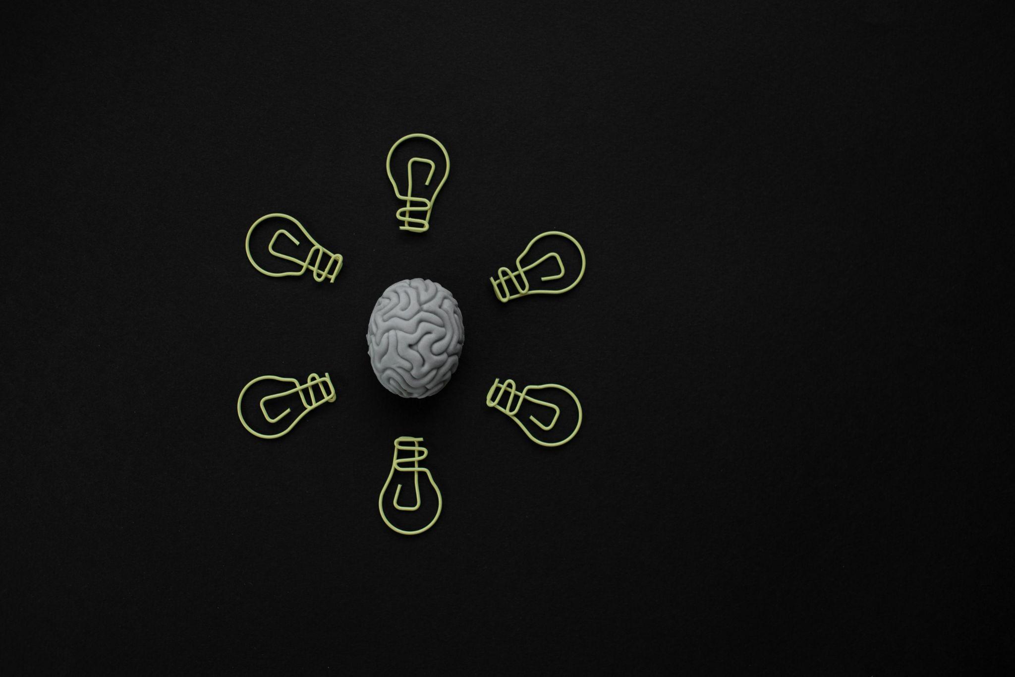 A brain model with lightbulbs circling it