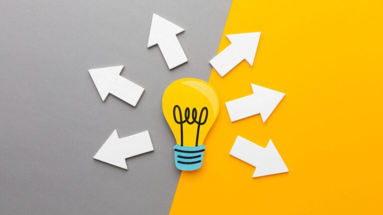 A glowing lightbulb with arrows pointing outward