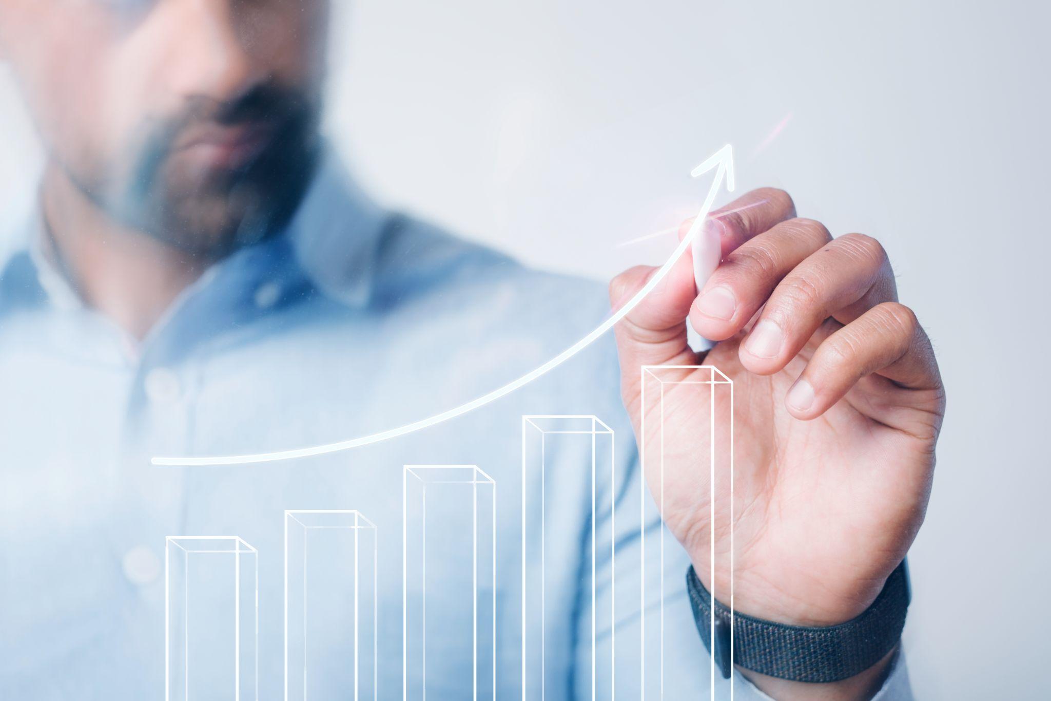 A man is drawing an increasing bar graph 