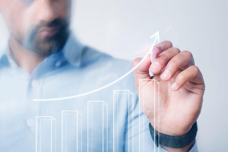 A man drawing an upward-trending graph to represent profit growth.